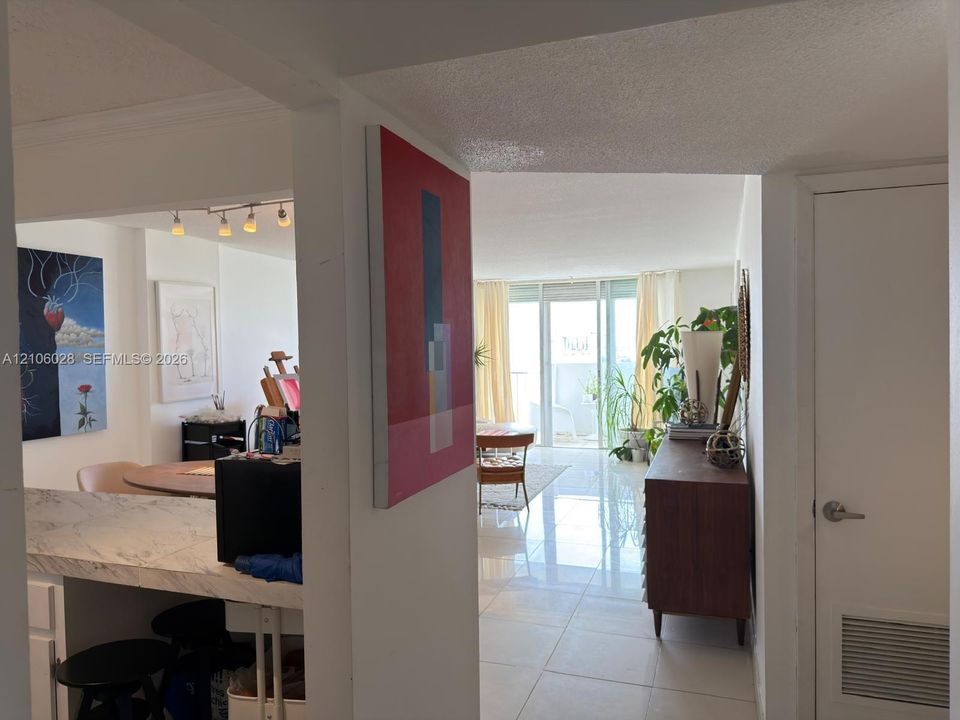 Polished stone flooring, counter with integrated stone-finish surface, and floor-to-ceiling glass sliding doors