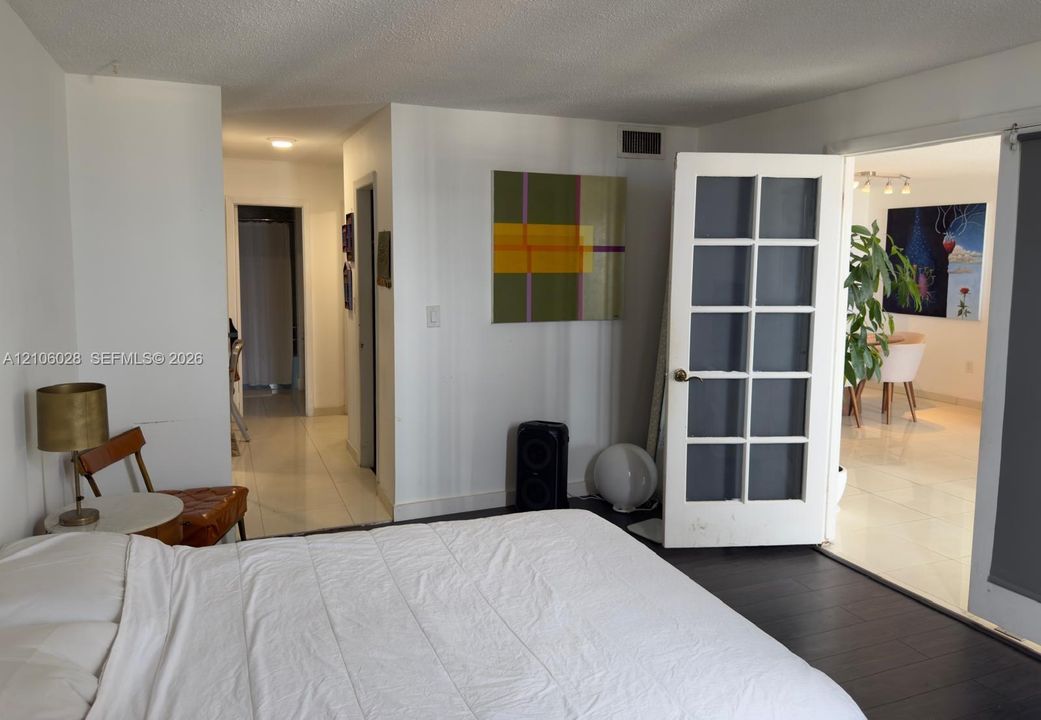Interior space featuring white walls, dark wood-finish flooring, and white gloss tile flooring