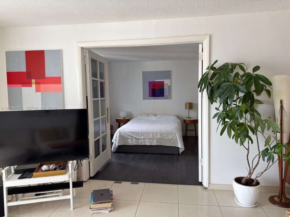 French-style double doors with glass paneling, tile flooring, and dark wood-finish flooring