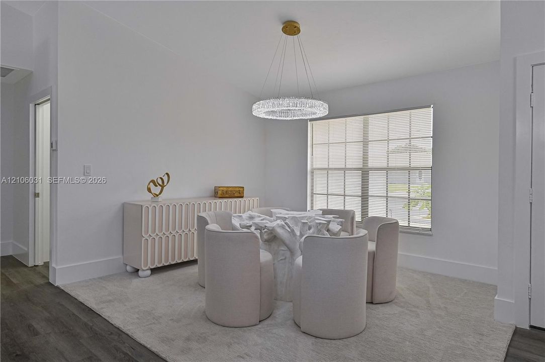 Circular crystal chandelier, multi-pane window, and wood-finish flooring