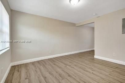 Interior space featuring wood-finish flooring, neutral wall paint, and a white ceiling-mounted flush light fixture