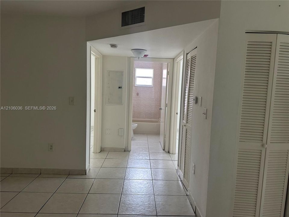 Ceramic tile flooring, louvered bi-fold closet doors, and flush-mount lighting fixture