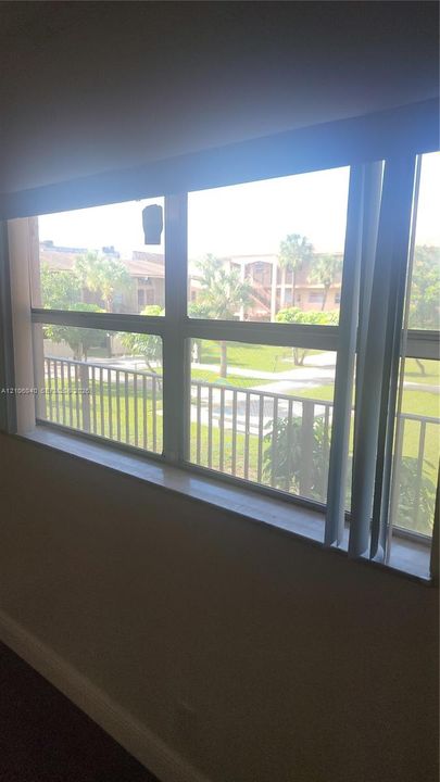 MASTER BDR North VIEW Large multi-pane window with a wide sill and vertical blind track