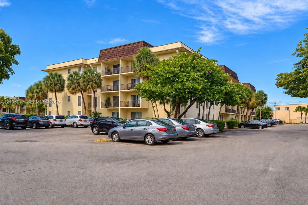 Multi-story building featuring stucco exterior, mansard roofline, and private recessed balconies