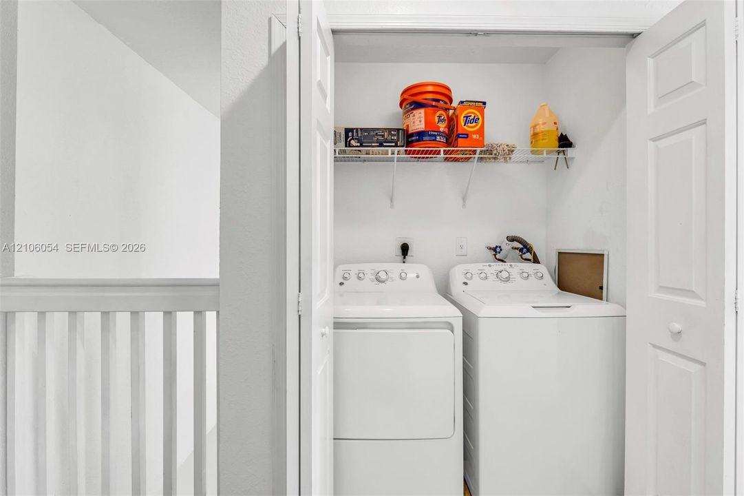 Laundry closet featuring bifold doors and a white wire shelving unit