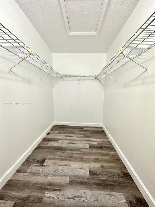 Storage space featuring wood-finish flooring and tiered wire shelving