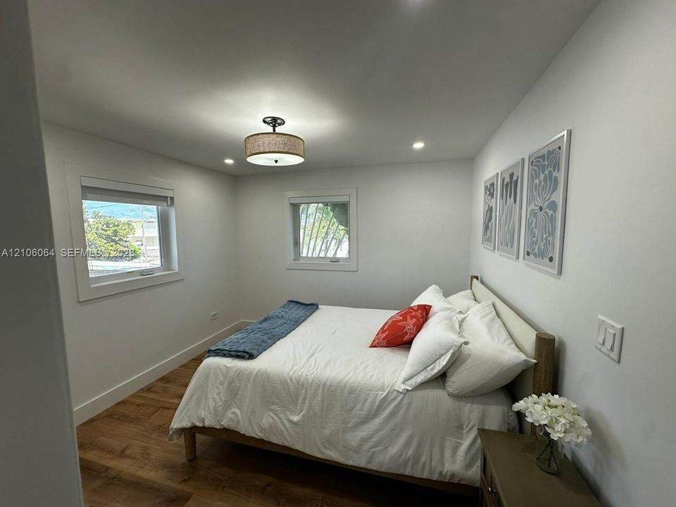 Wood-finish flooring, recessed ceiling lighting, a drum shade flush-mount fixture, and double-pane windows
