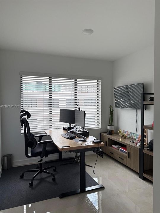 Neutral wall finishes, polished tile flooring, and a window with horizontal blinds