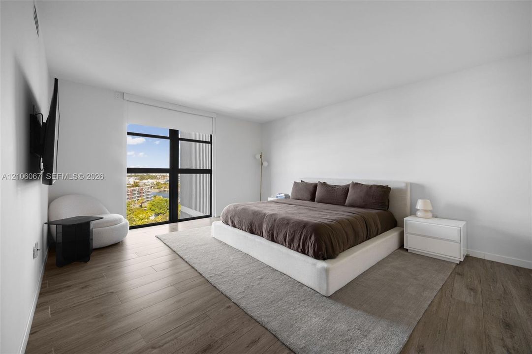 Floor-to-ceiling windows with dark framing, wood-finish flooring, and high ceilings