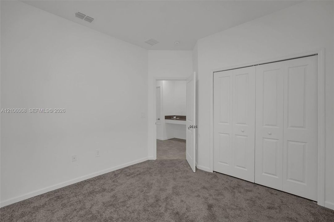 Neutral interior featuring plush wall-to-wall carpeting and a double-door closet with paneled detailing