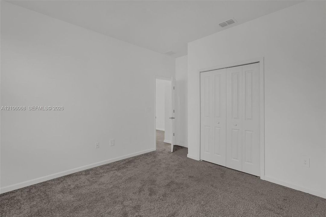Neutral interior featuring plush wall-to-wall carpeting and a bi-fold closet with white panel doors
