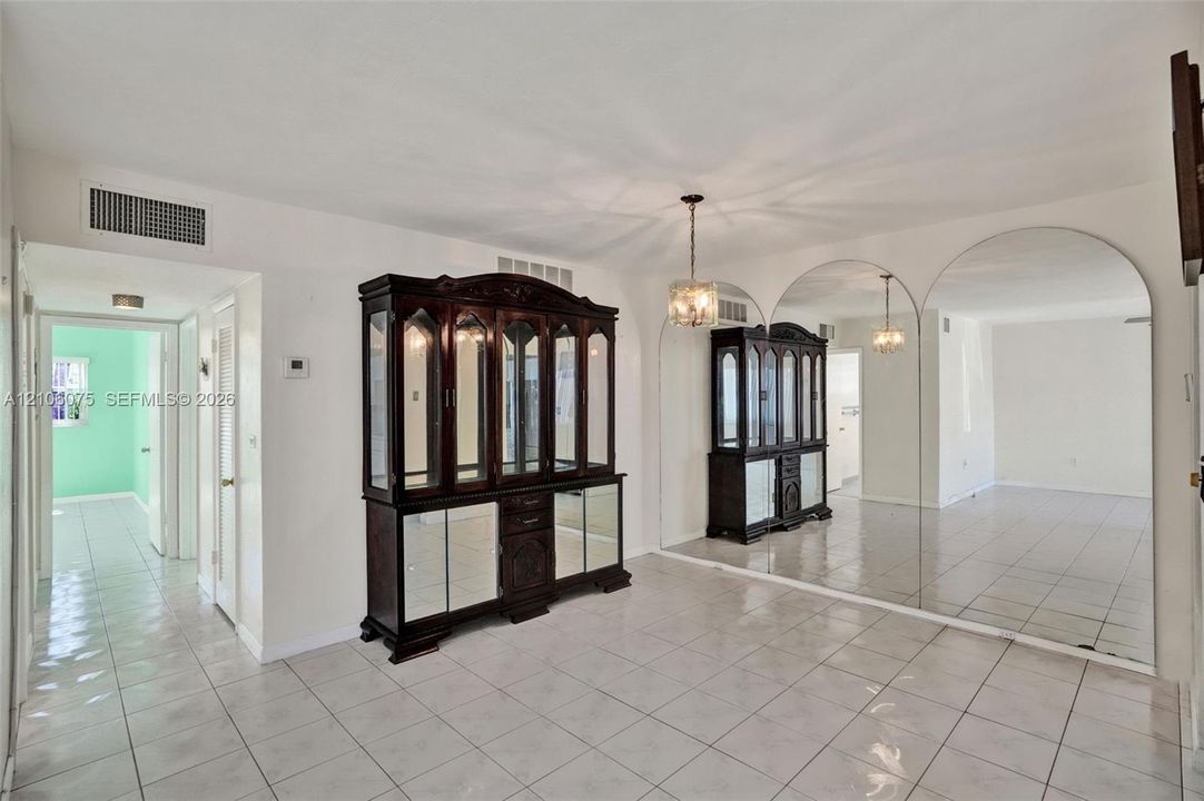 Ceramic tile flooring, full-wall arched mirrors, and an attached multi-arm pendant light fixture