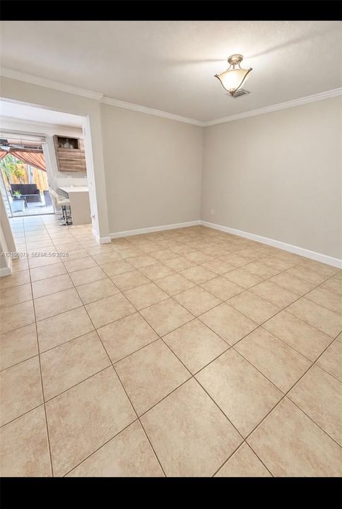 Ceramic tile flooring throughout with crown molding and a flush-mount geometric ceiling light fixture