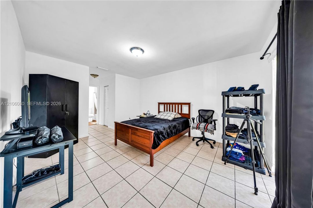 Ceramic tile flooring, neutral wall finishes, and a flush-mount ceiling light fixture