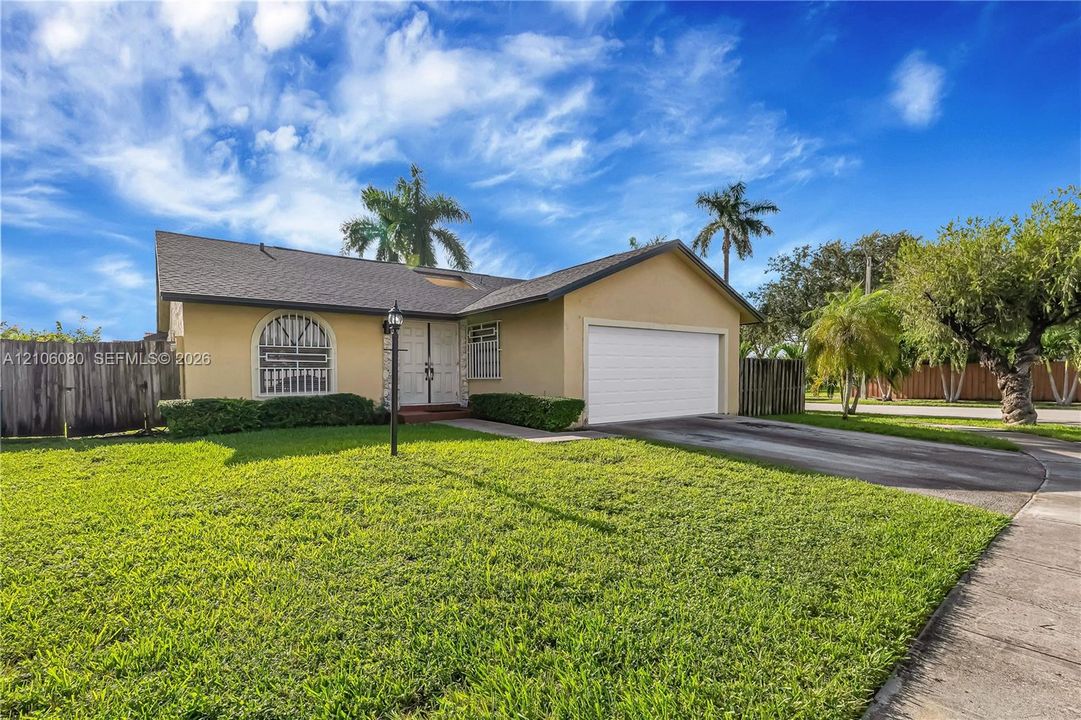 Stucco exterior residence featuring an arched window, double-door entry, and an attached two-car garage
