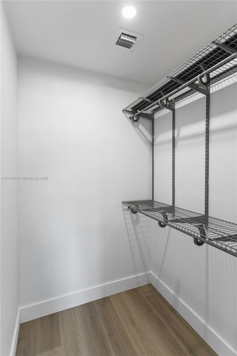 Storage area featuring wood-finish flooring and integrated multi-tier wire shelving