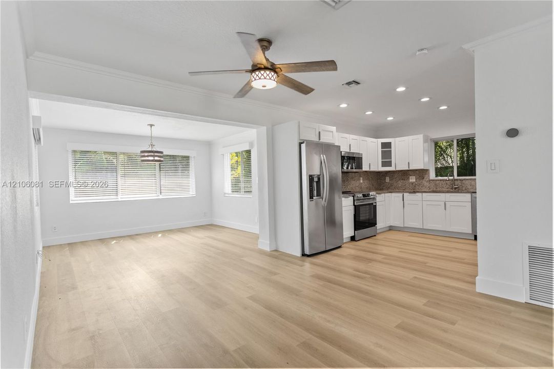 Kitchen featuring white cabinetry, stainless steel appliances, wood-finish flooring, recessed lighting, and a ceiling fan