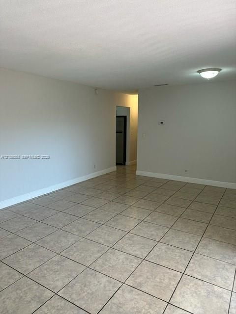Neutral-toned interior space featuring tile flooring and a ceiling-mounted light fixture