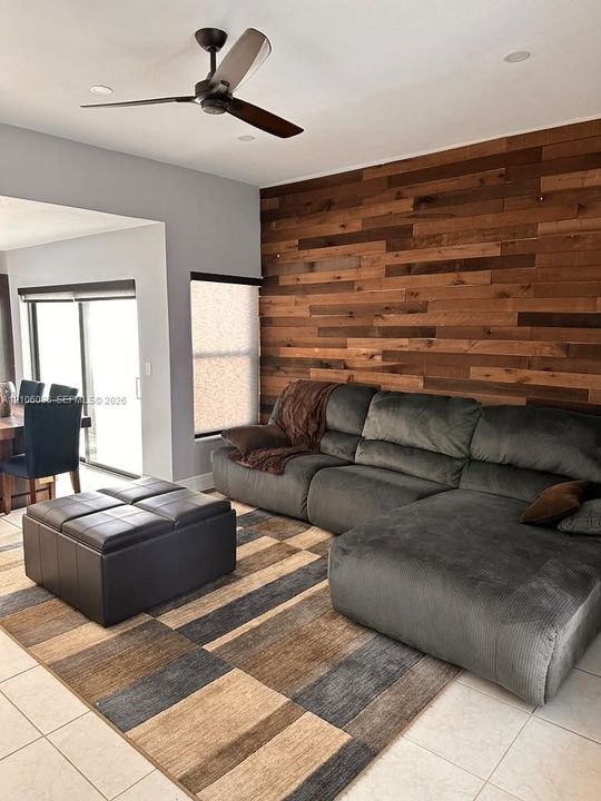 Accent wall featuring horizontal wood paneling, tile flooring, recessed ceiling lighting, and a modern matte-finish ceiling fan