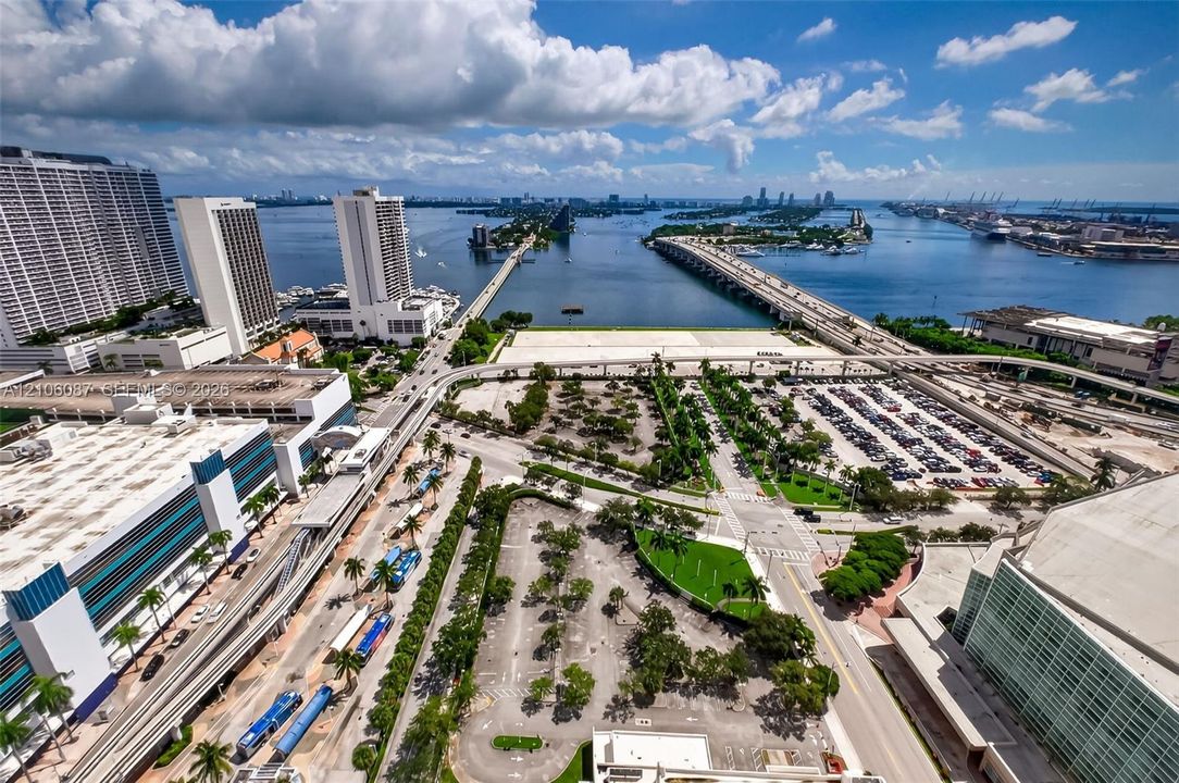Aerial perspective showcasing high-density urban infrastructure, expansive waterfront proximity, multi-lane causeway systems, and integrated public transportation corridors