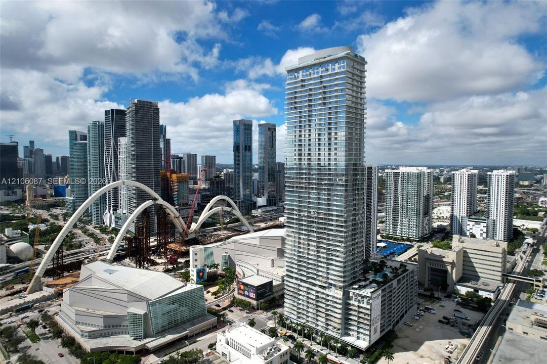High-rise glass facade residential tower featuring wrap-around balconies and an elevated pool deck
