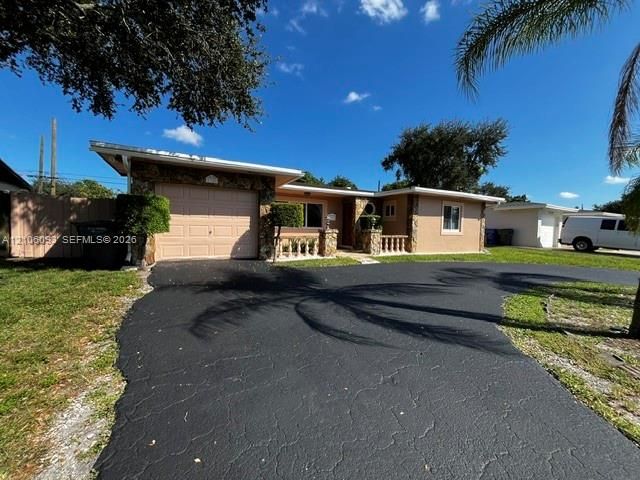 Single-story exterior featuring stone veneer accents, a covered entryway with concrete balustrades, an attached one-car garage, and an asphalt driveway