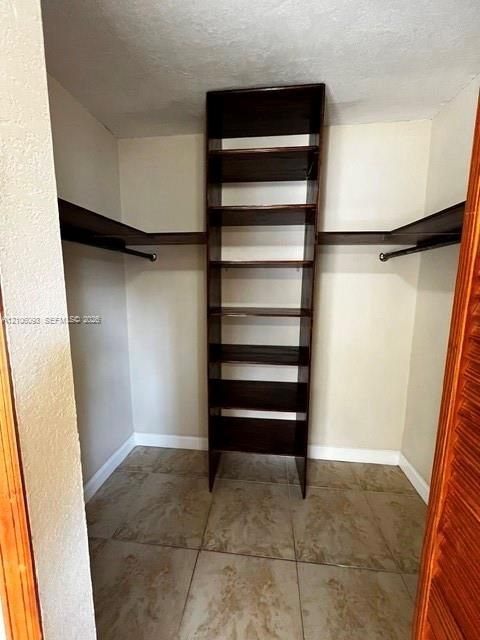 Built-in vertical wood shelving tower, dual hanging rods, and tile flooring