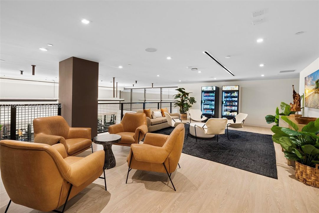 Open-concept lounge featuring wood-finish flooring, recessed lighting, and a metal-grid balcony railing