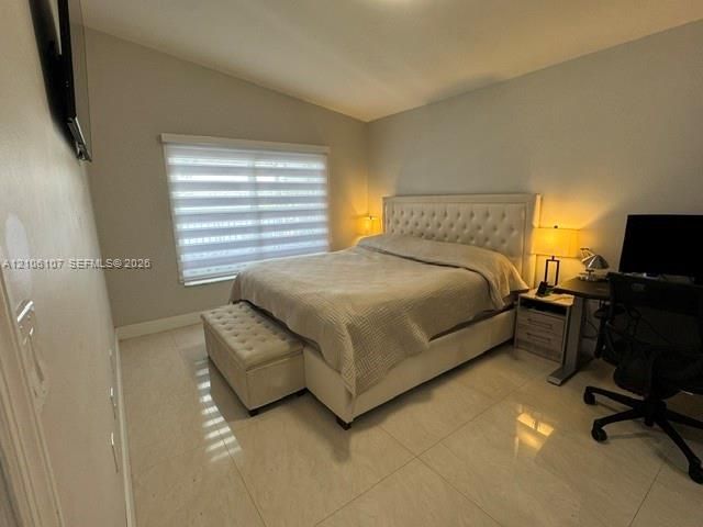 Room featuring large-format tile flooring, vaulted ceilings, and horizontal sheer window treatments