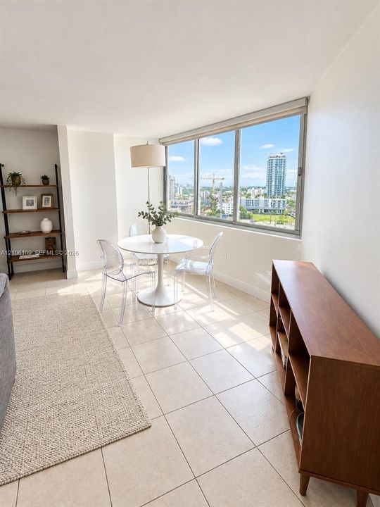 Expansive floor-to-ceiling windows featuring panoramic urban scenery and light-toned tile flooring