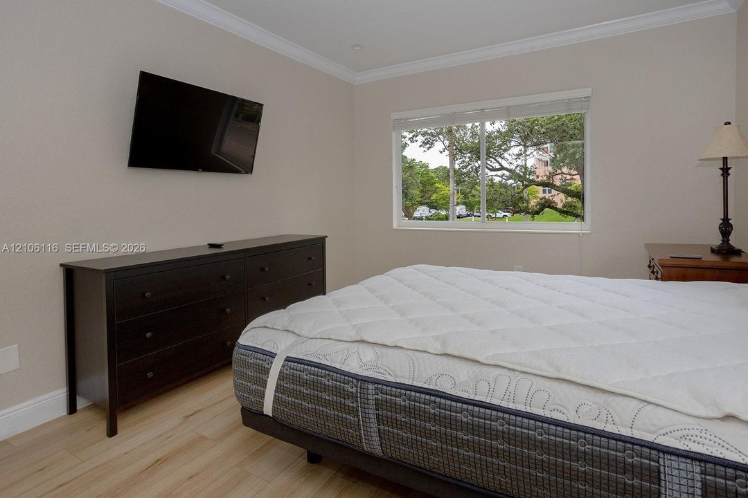 Neutral wall coloring, crown molding, wood-finish flooring, and horizontal sliding window
