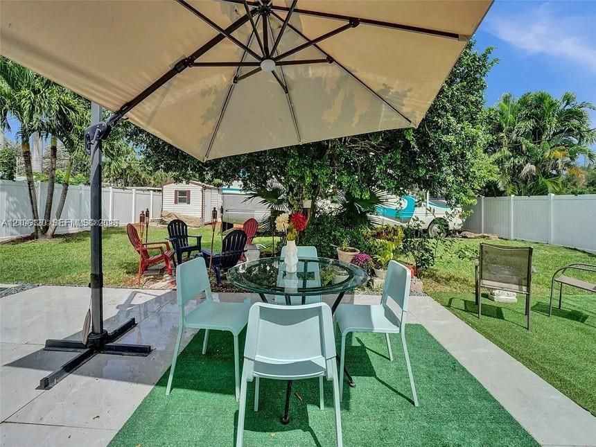 Outdoor patio area featuring large-format porcelain tile flooring and a perimeter privacy fence