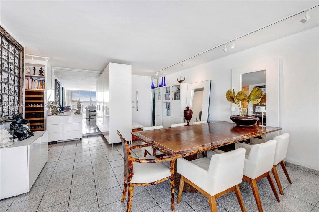 Large-format tile flooring, built-in floor-to-ceiling white cabinetry, integrated wine storage, and professional-grade track lighting