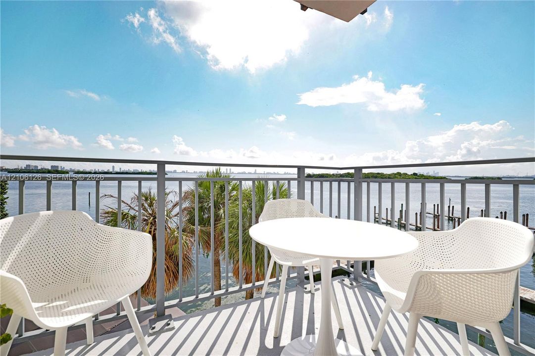 Private balcony featuring metal railings and concrete flooring, overlooking the water