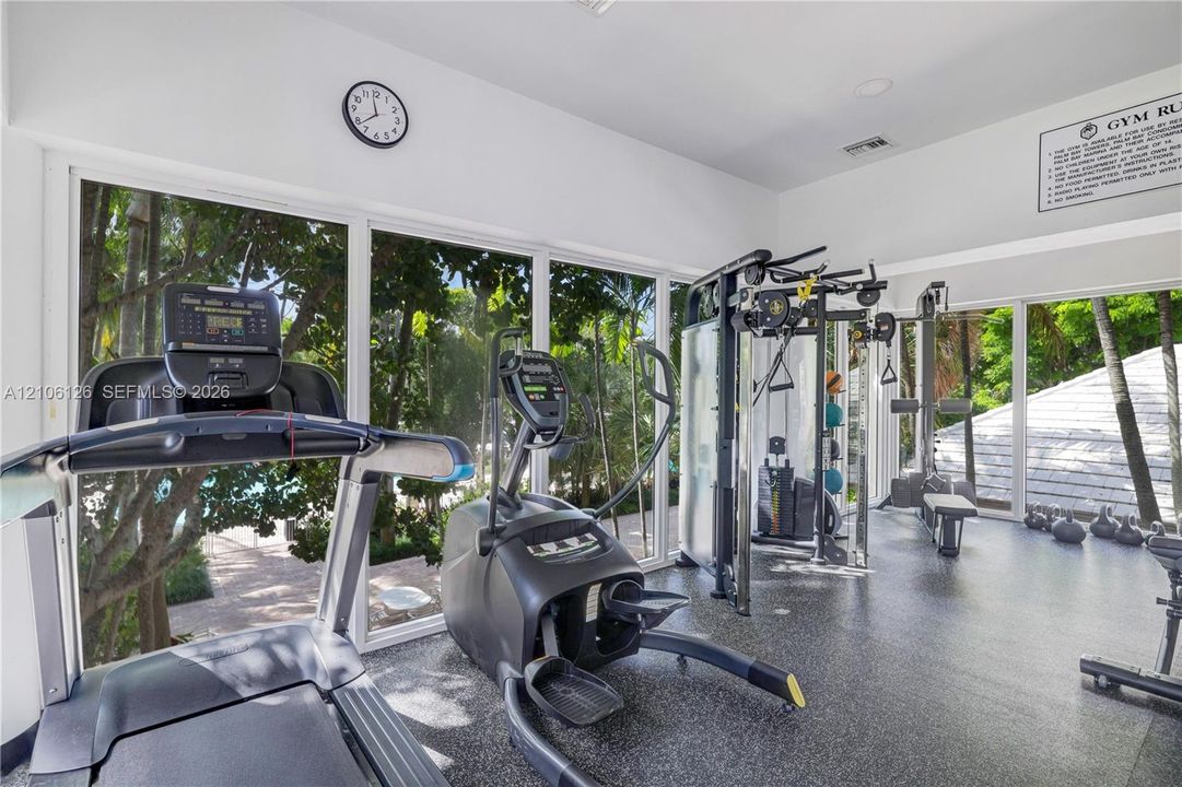 Fitness room featuring full-height floor-to-ceiling windows, recessed lighting, and durable rubber flooring