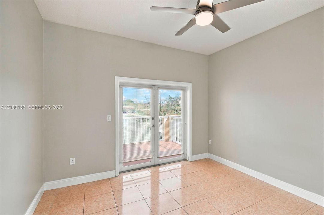 Room featuring neutral wall paint, tile flooring, and a ceiling fan with integrated lighting