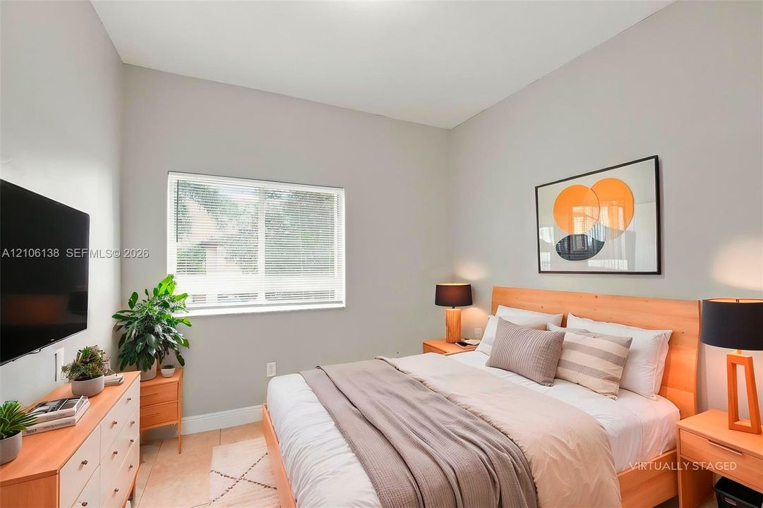 Neutral-toned interior space featuring light-colored wall paint, tile flooring, and a window with horizontal blinds