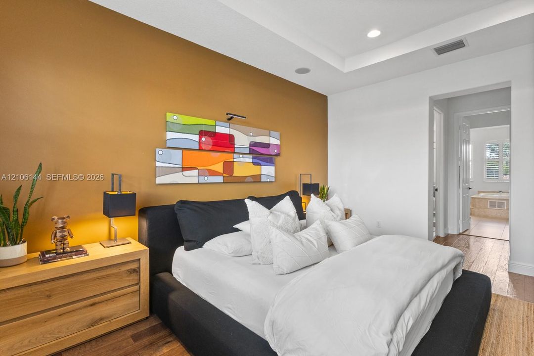 Tray ceiling with recessed lighting and wood-finish flooring