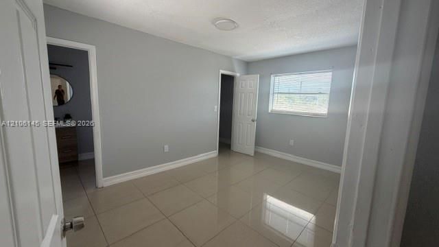 Interior space featuring neutral wall paint, large-format tile flooring, a horizontal slider window, and interior paneled doors