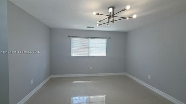 Neutral wall tones, polished tile flooring, and a multi-arm sputnik-style chandelier