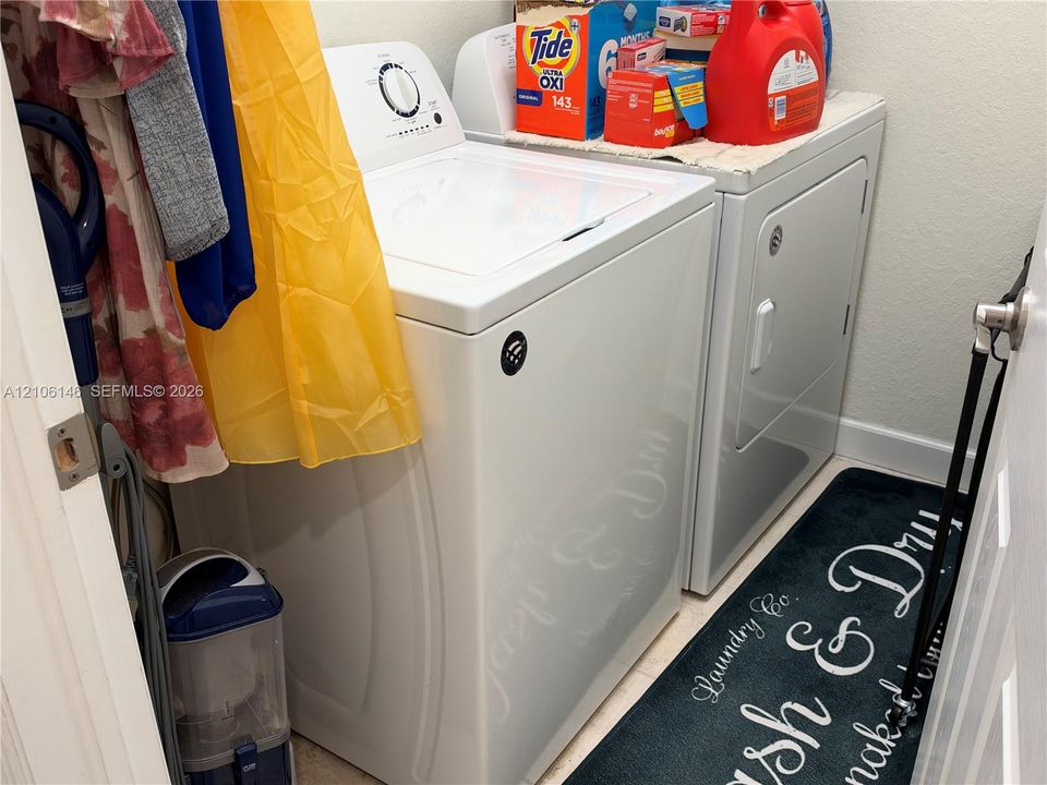 Laundry space featuring a top-load washer and side-by-side dryer