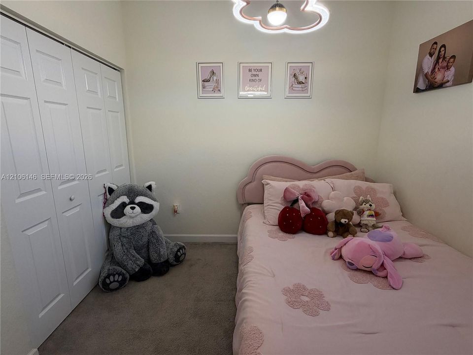 Room featuring carpeting, bi-fold closet doors, and a decorative cloud-shaped ceiling light fixture