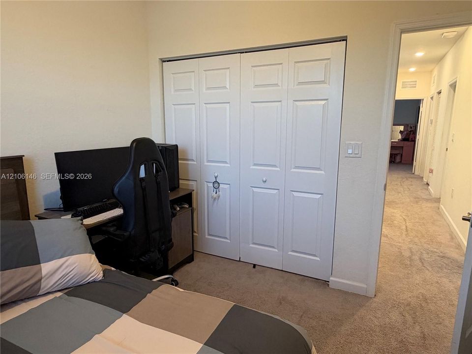 Room featuring carpeting and a double-door closet with raised-panel detailing