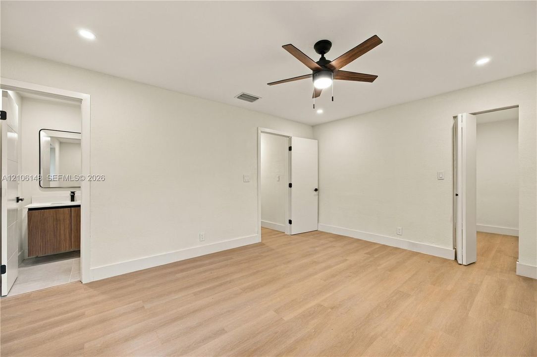 Room featuring wood-finish flooring, recessed lighting, and a central ceiling fan with integrated lighting