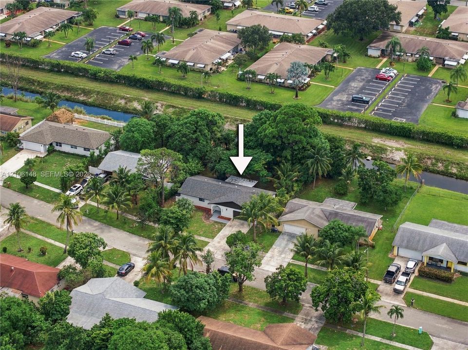 Single-story residence featuring a shingle roof, concrete driveway, and mature landscaping