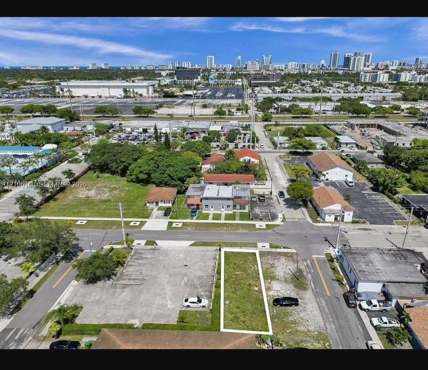 Cleared rectangular lot featuring corner street access and a concrete-surfaced perimeter