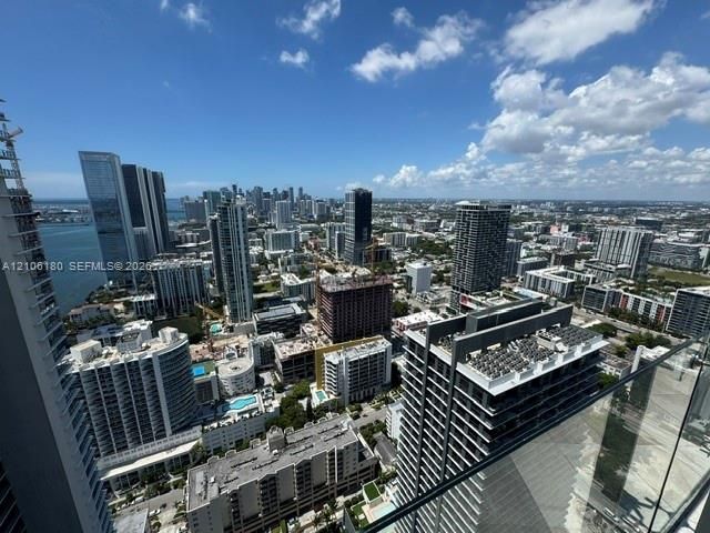 High-rise balcony featuring a glass panel railing and panoramic metropolitan skyline surroundings