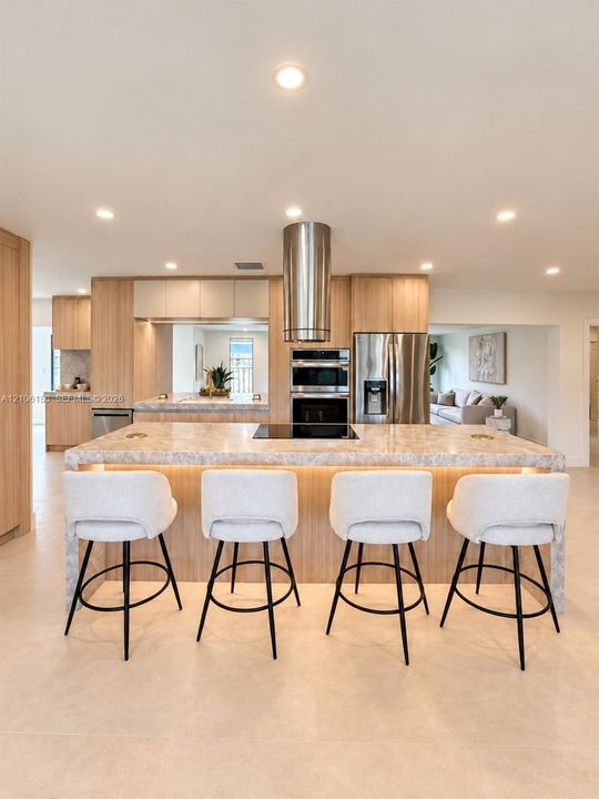 Kitchen featuring a central island with integrated cooktop, stone-finish countertops, stainless steel cylindrical range hood, custom wood-finish cabinetry, and recessed ceiling lighting