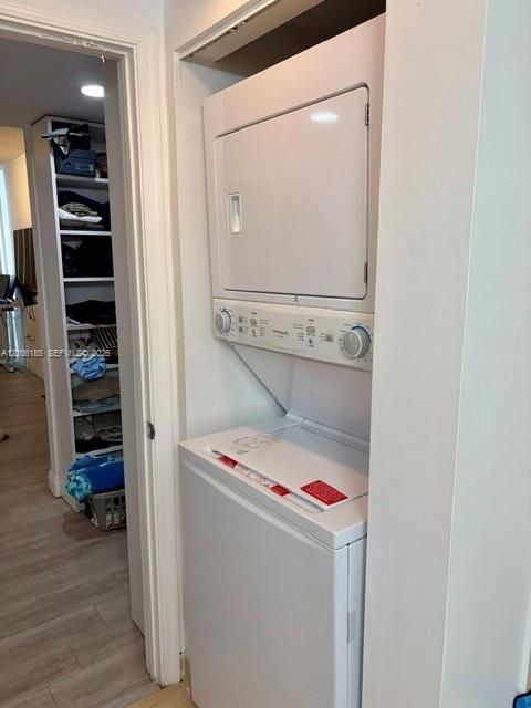 Stacked laundry unit with white finish and integrated shelving with multiple storage levels