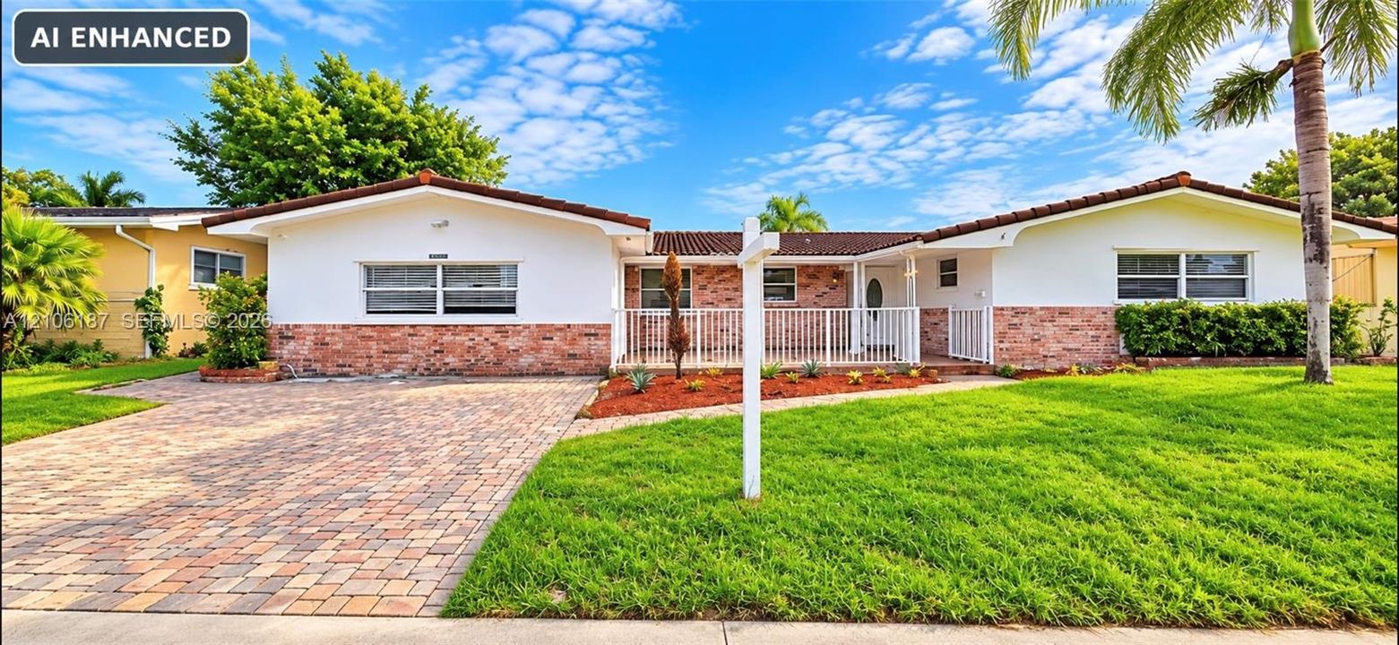 Single-story exterior featuring a brick and stucco facade, decorative tile roof, paved driveway, and white metal front railing